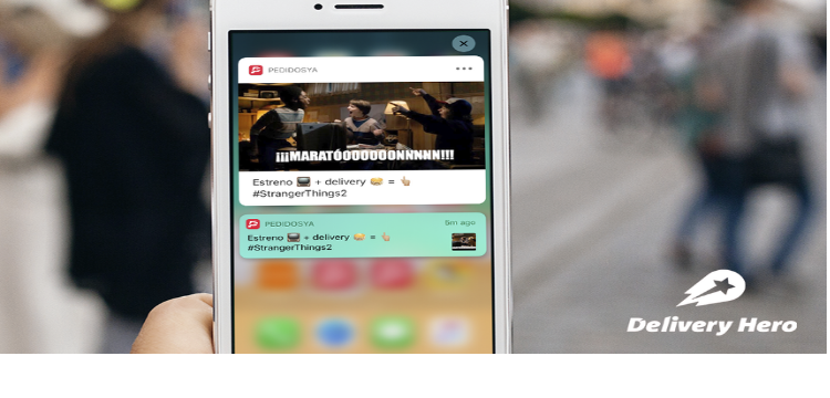 Image of mobile phone with notification on screen and delivery hero branding.