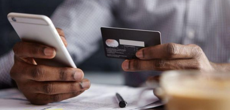 Image of hands holding a mobile phone and credit card