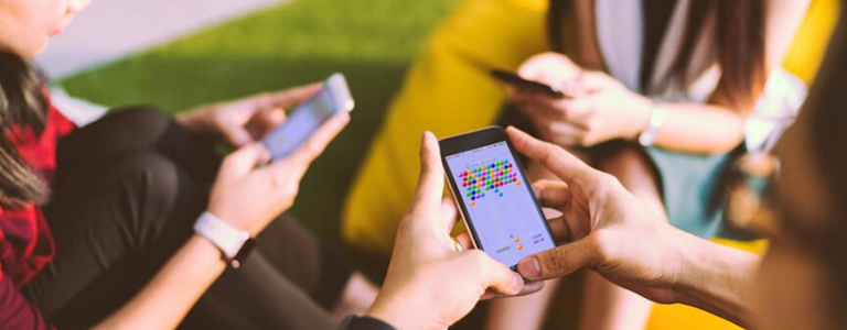 Image of people sitting on bean bags and playing games on mobile phones