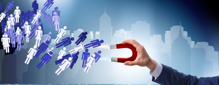 Image of hand holding magnet pulling human like shapes towards magnet