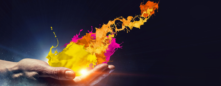 Hand holding a orb of light and a splash of yellow, pink and orange paint